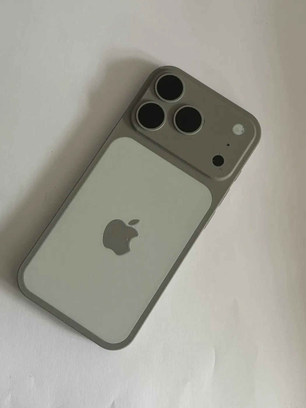 A 3D-printed model shaped like the back of a phone, in grey and white